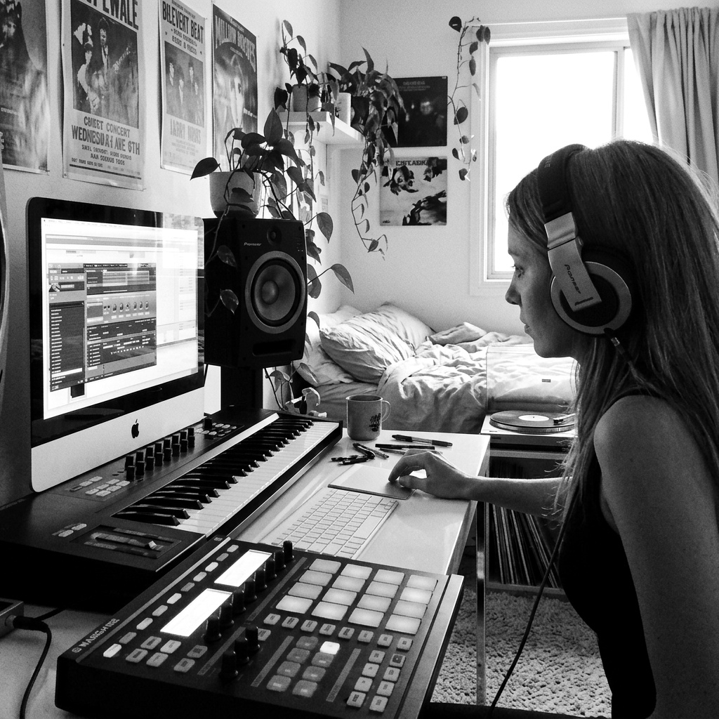 An artist working at a home studio setup, learning in a digital audio workstation